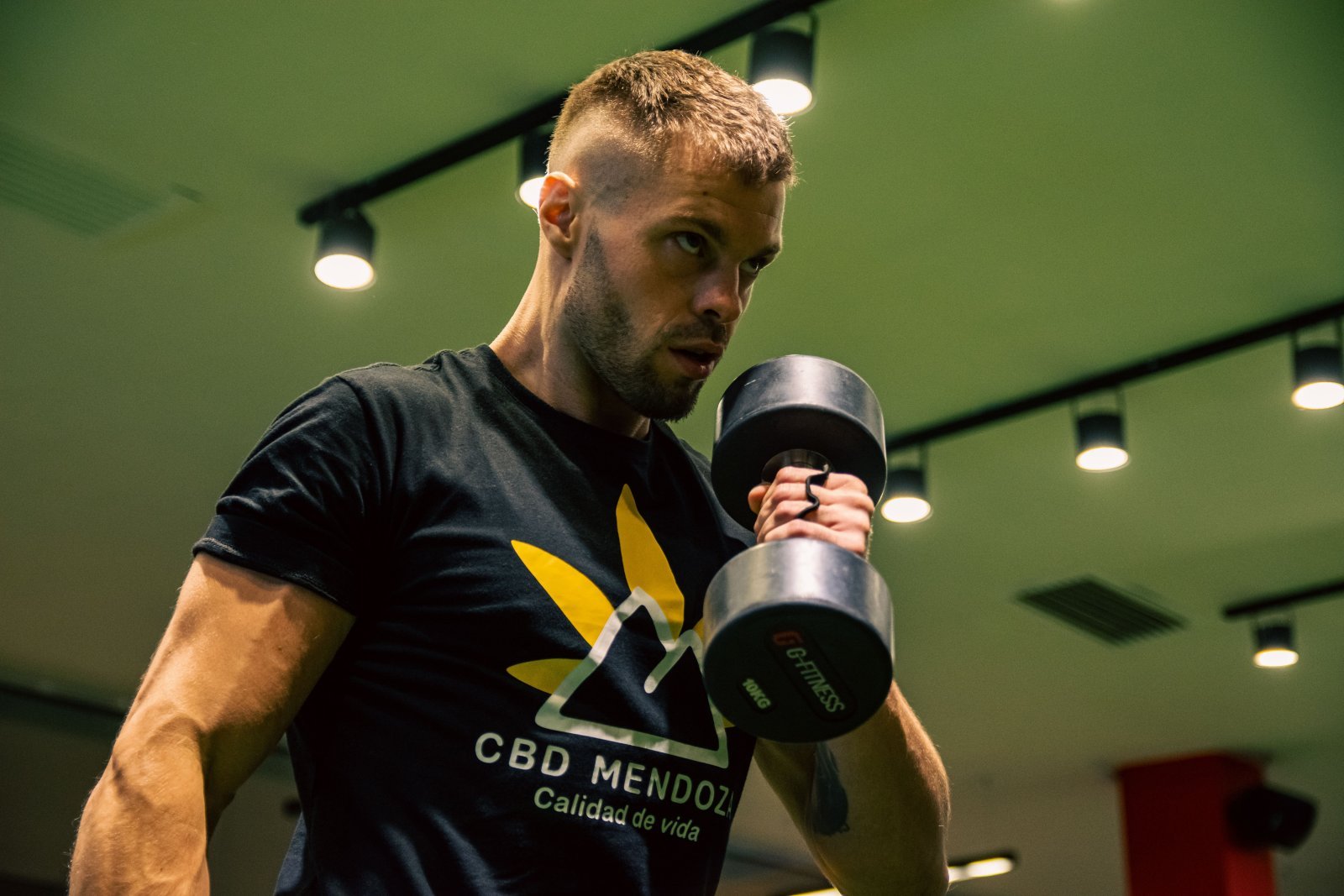 A man in gym performing dumbbell curls