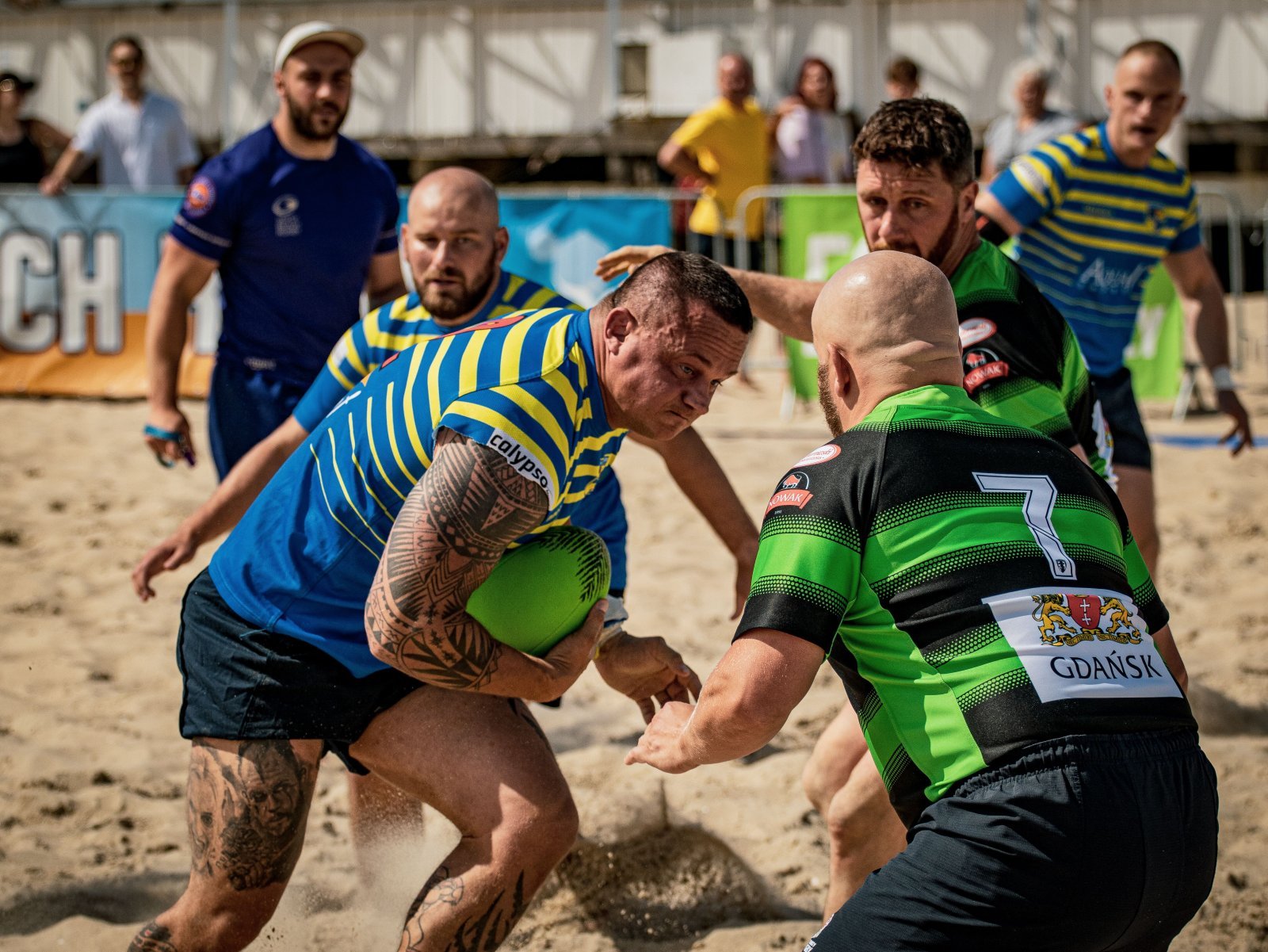 Photo of a group of men playing rugby, with a couple being bald