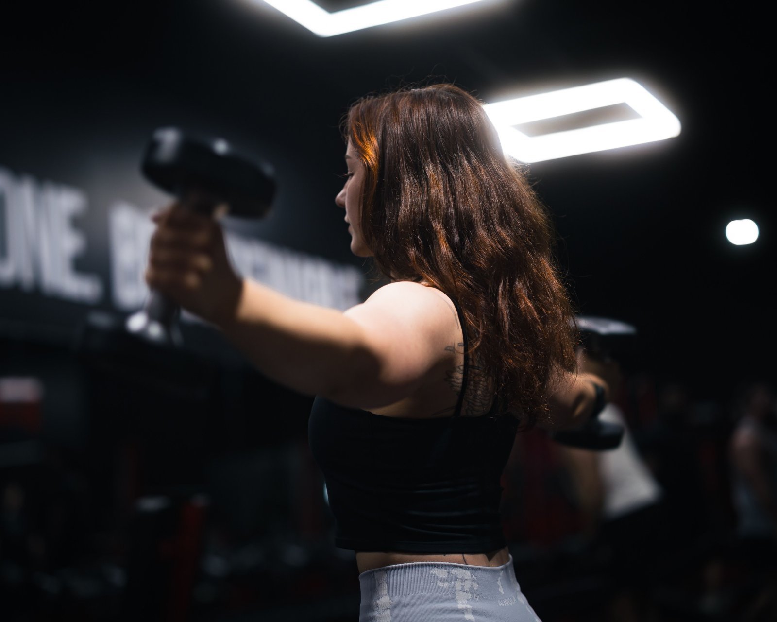 A woman in a gym lifting weights
