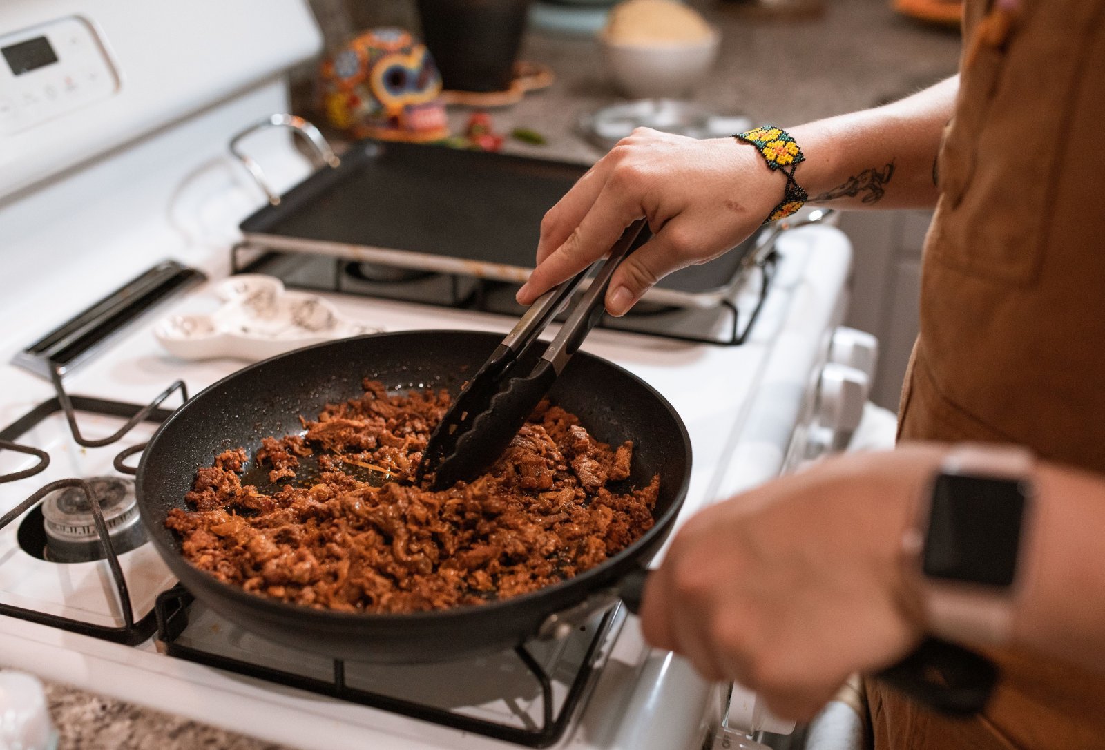 Photo of a man cooking grass fed ground beef in a skillet