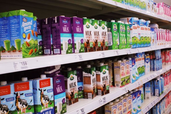 A grocery aisle containing different types on milk