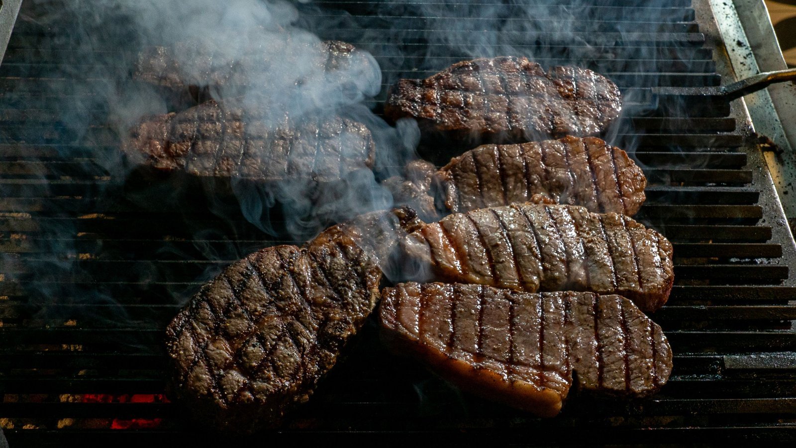 A photo of some steaks on the grill