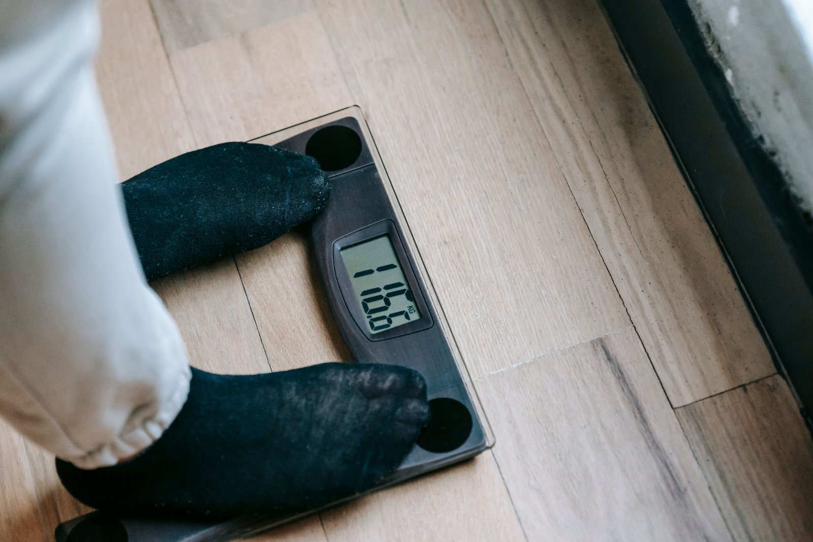 Photo of a person standing on a scale weighing themselves
