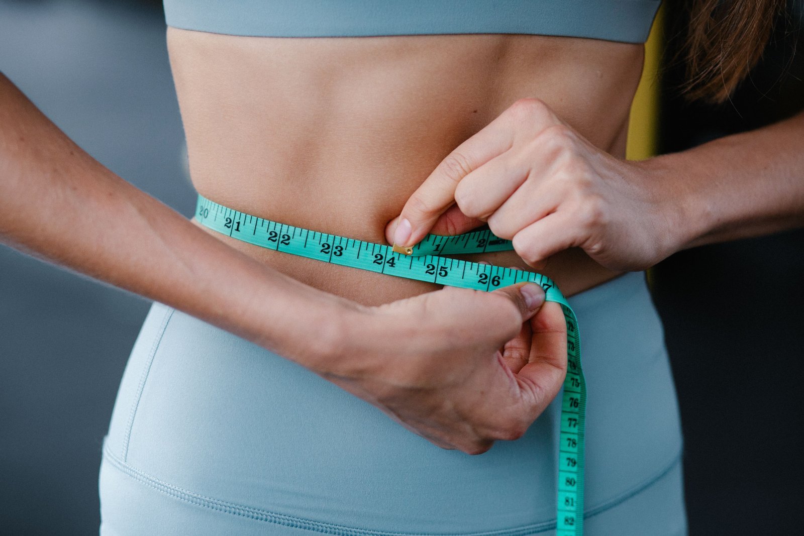 Photo of a woman measuring her waist to see how much weight she lost