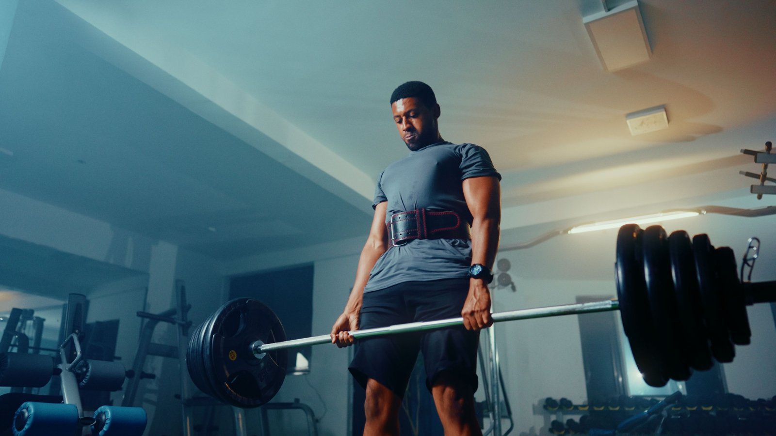 A man in the gym performing a compound lifting exercise